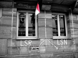 Altstadt Sandsteinfassade mit aufgemalter Beschriftung LSR und Pfeilen